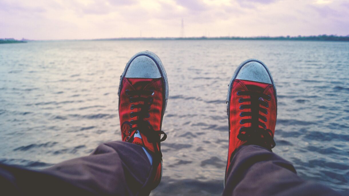 Rote Schuhe über Wasser hängend